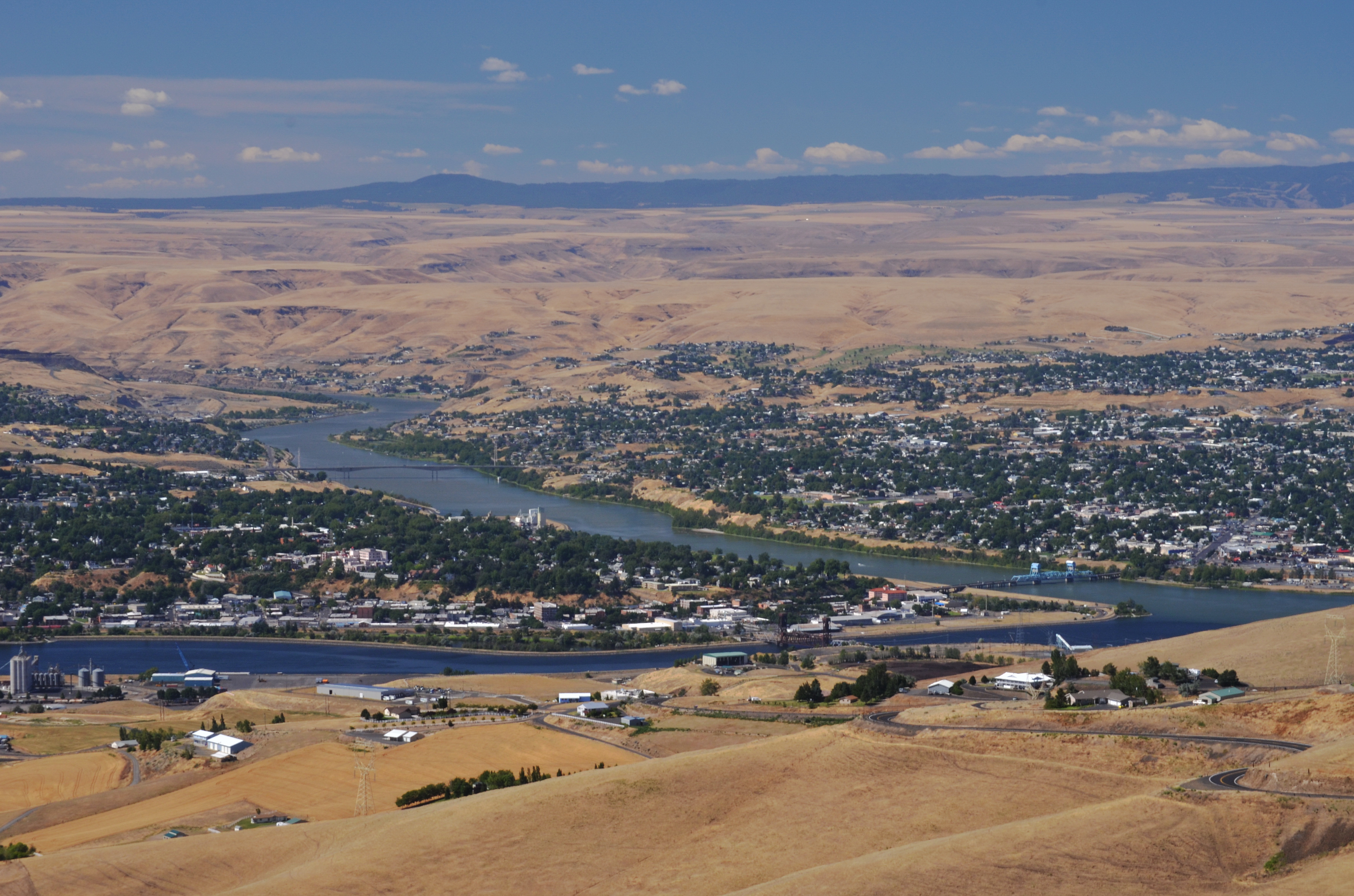 Aerial view of Lewiston, Idaho and Clarkston, Washington at the confluence of the Snake and Clearwater rivers, surrounded by dry golden hills.